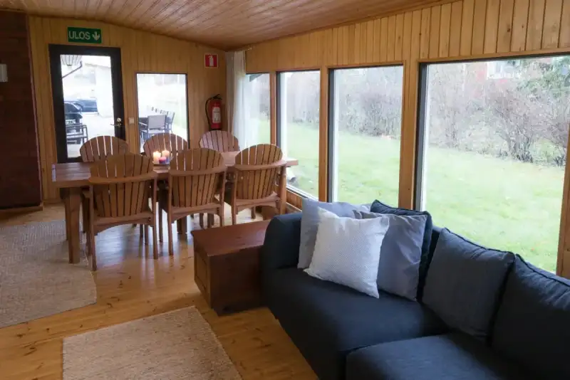 Viihtyisä oleskelutila sohvalla ja puisella ruokapöydällä